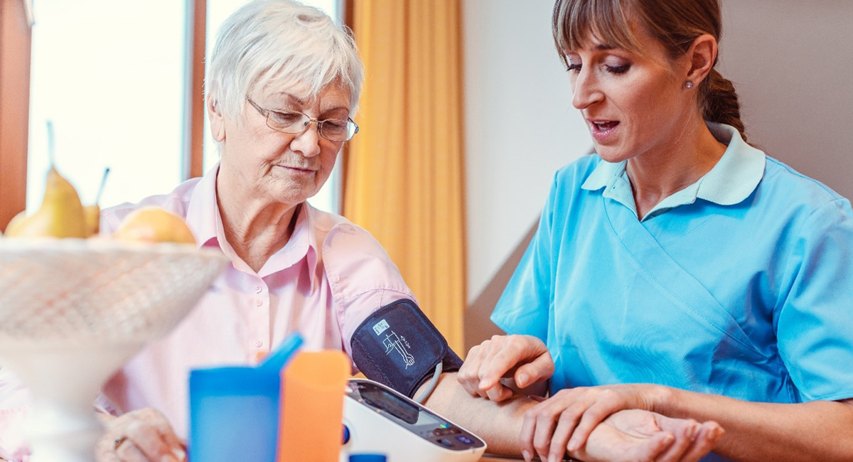 A carer checks the BP of an elderly while providing homecare services.