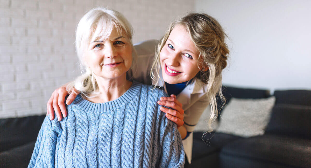 A care assistant offering an elderly woman befriending services.