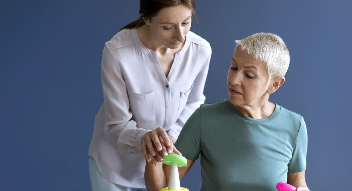 A caregiver providing care to an elderly woman with dementia care