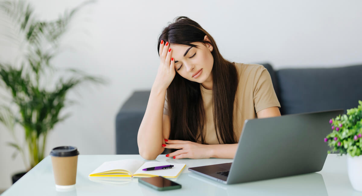 A caregiver facing emotional challenges sitting in front of a laptop.