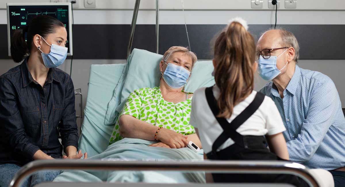 An elderly person receiving end-of-life care from family members and caregivers.