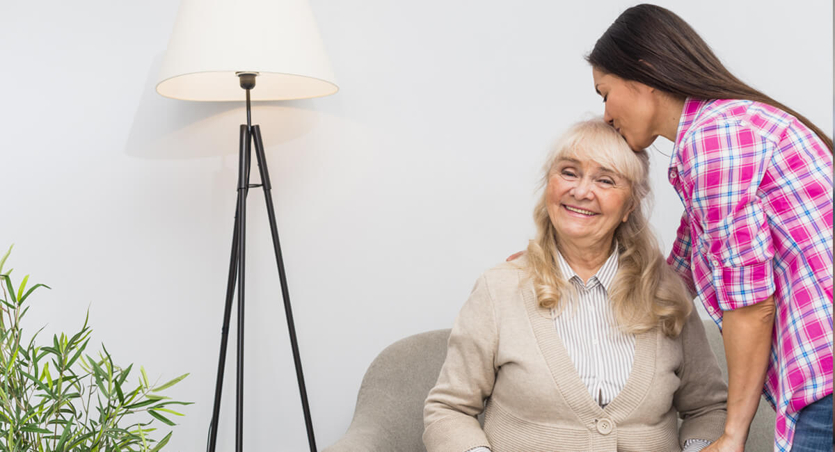 A caregiver assisting an elderly lady suffering from Parkinson's disease