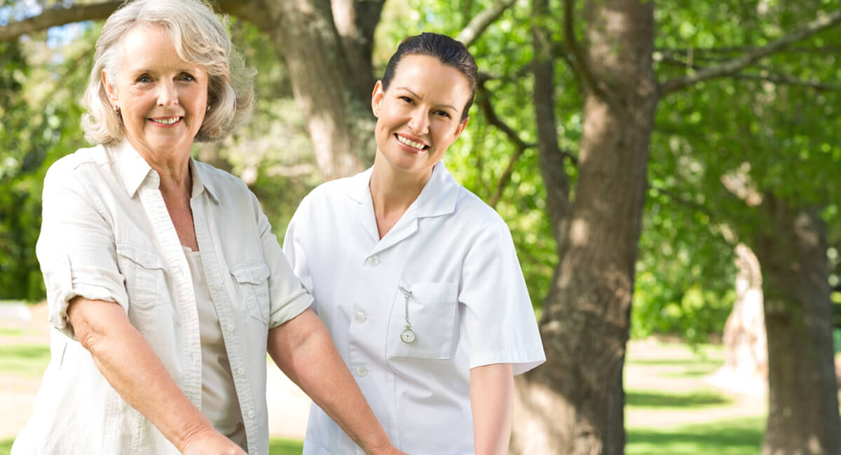 A caregiver providing companionship care to an elderly disabled woman